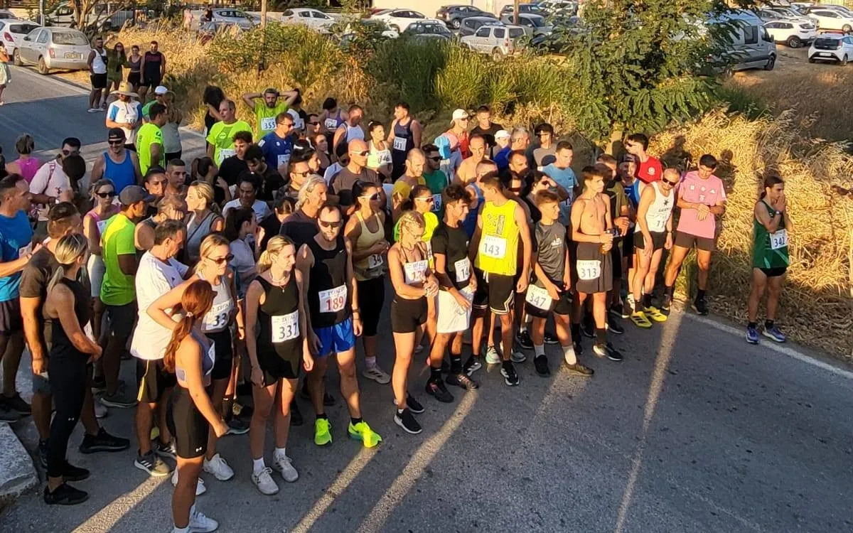Δρομείς με αριθμούς συμμετοχής συγκεντρωμένοι πριν από την εκκίνηση των Ερημακείων 2025 σε ασφάλτινο δρόμο.