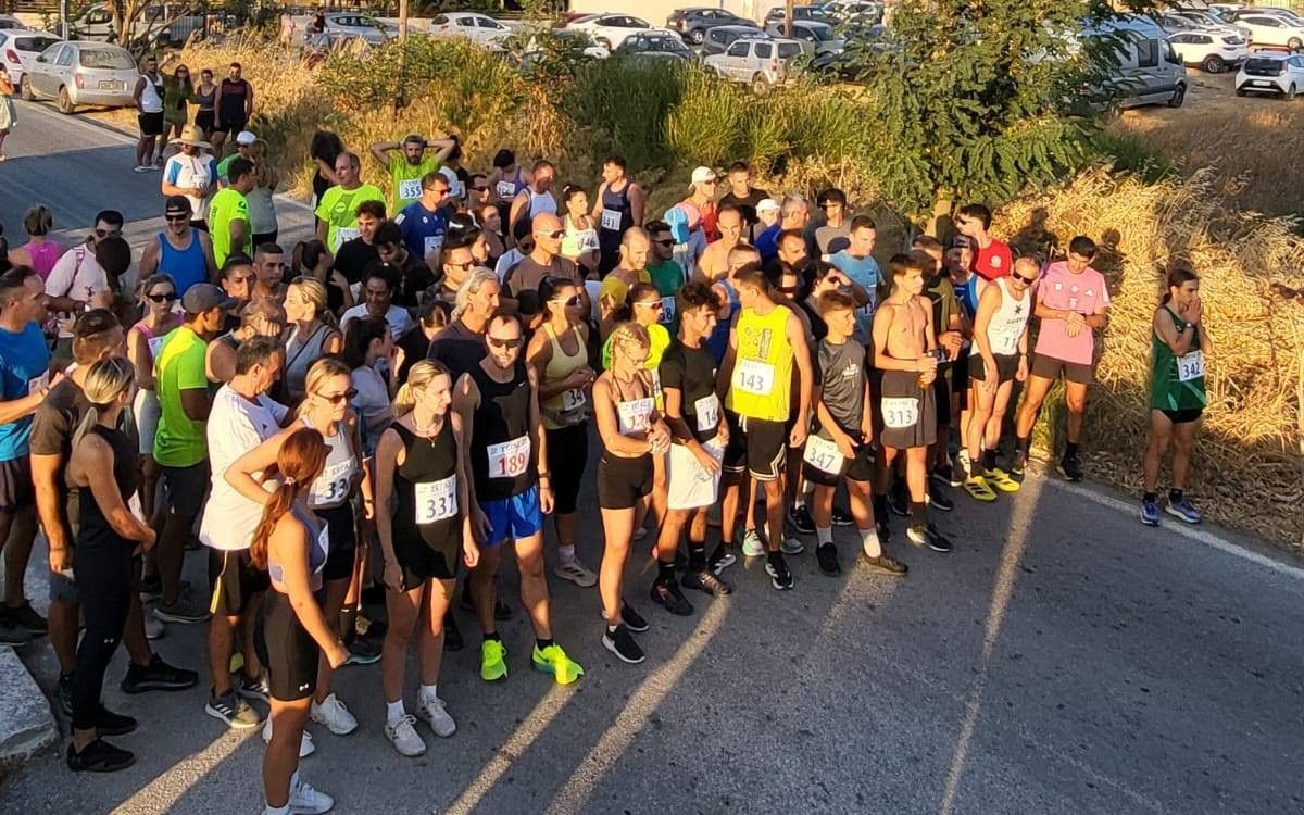 Δρομείς με αριθμούς συμμετοχής συγκεντρωμένοι πριν από την εκκίνηση των Ερημακείων 2025 σε ασφάλτινο δρόμο.